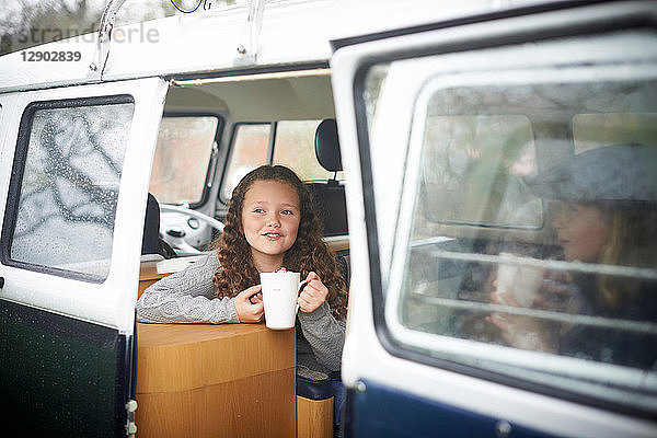 Mädchen mit heißer Schokolade unterhalten sich im Wohnmobil