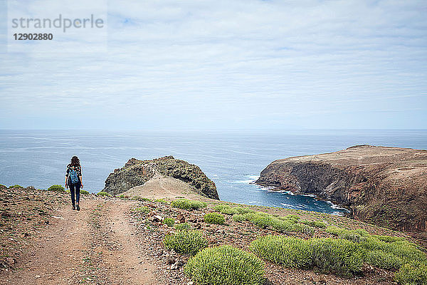 Frau wandert auf unbefestigtem Küstenweg  Las Palmas  Gran Canaria  Kanarische Inseln  Spanien