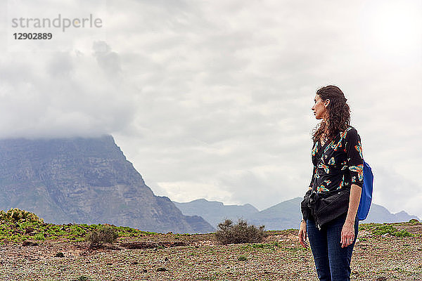 Frau blickt auf niedrige Wolke über den Bergen  Las Palmas  Gran Canaria  Kanarische Inseln  Spanien