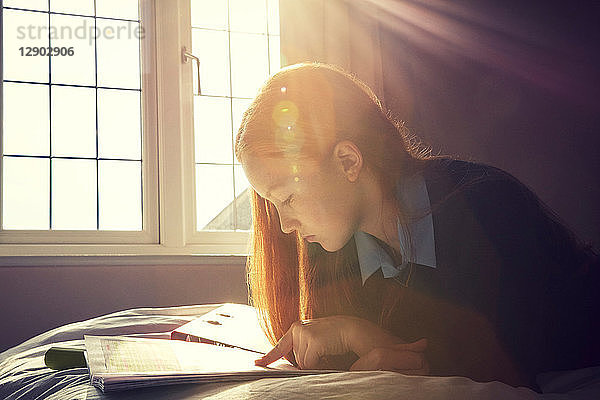 Teenagerin beim Lesen im Bett