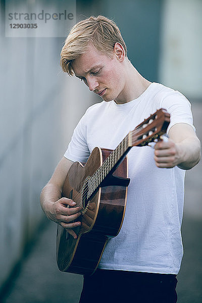 Junger Musiker  der Gitarre spielt