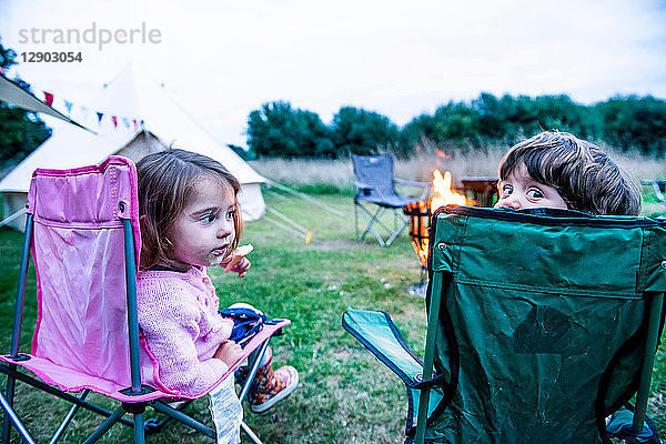 Kinder entspannen sich vor dem Lagerfeuer