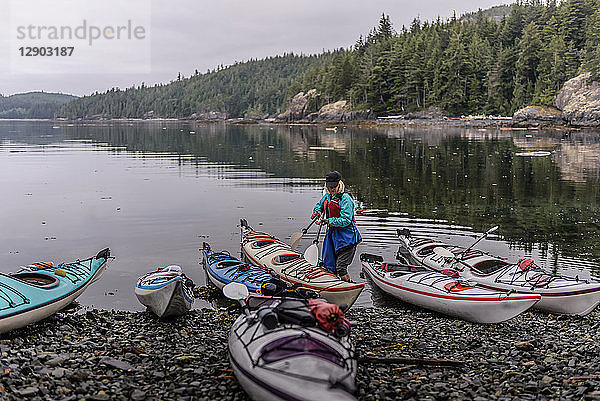 Frau mit Seekajaks am Seeufer  Johnstone Strait  Telegraph Cove  Kanada