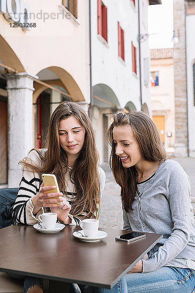 Freundinnen mit Mobiltelefon im Café  Belluno  Venetien  Italien