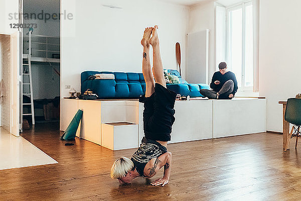 Frau  die zu Hause Yoga praktiziert  Freundin im Hintergrund