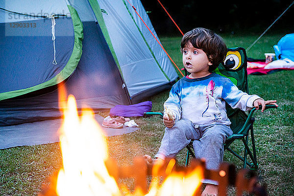 Kind entspannt sich vor dem Lagerfeuer