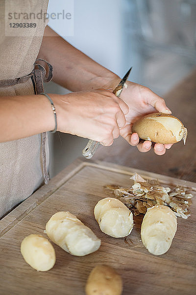 Frau schält Kartoffeln für Gnocchi