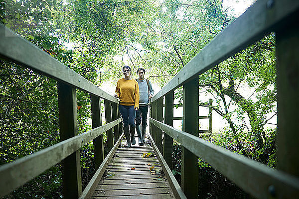 Wandererpaar überquert Holzbrücke