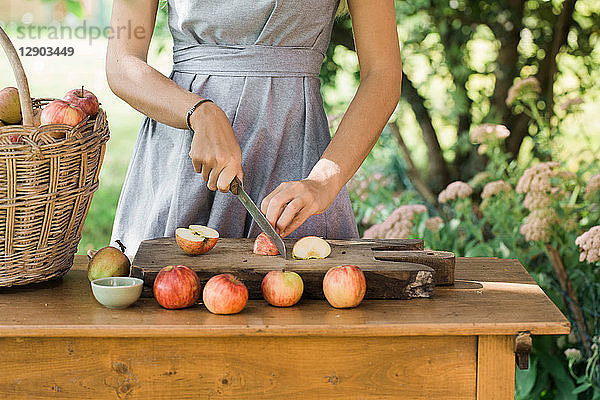 Frau schneidet Äpfel auf dem Tisch