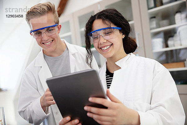 SchülerInnen mit digitalem Tablett im Labor