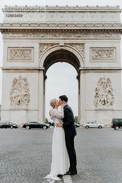 Küssende Braut und Bräutigam  Triumphbogen im Hintergrund  Paris  Frankreich