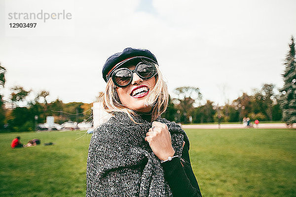 Blonde Frau mit Sonnenbrille im Park  Porträt