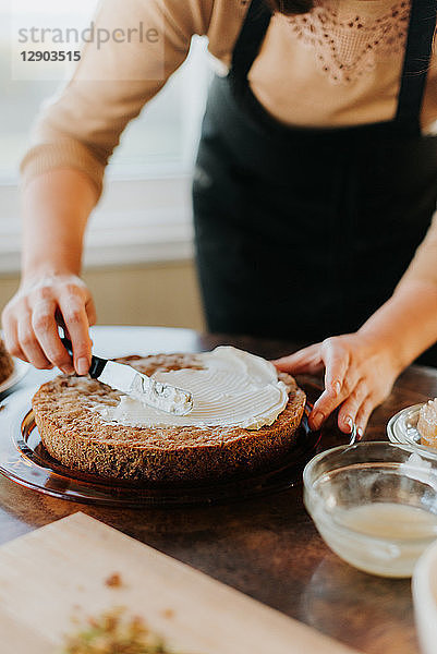 Frau mit Schürze backt vegetarischen Kuchen