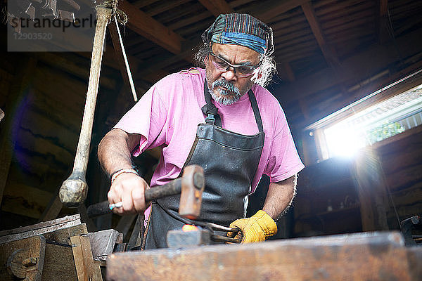 Der Schmied arbeitet in seiner Schmiede