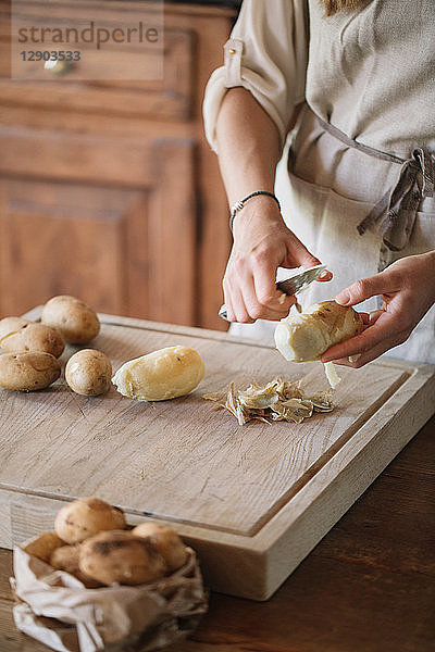Frau schält Kartoffeln für Gnocchi