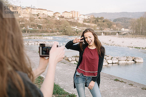 Freundinnen beim Fotografieren am Fluss  Belluno  Venetien  Italien