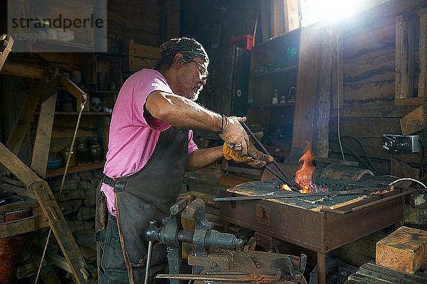 Der Schmied arbeitet in seiner Schmiede