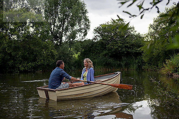 Erwachsenes Paar im Ruderboot auf einem ländlichen See