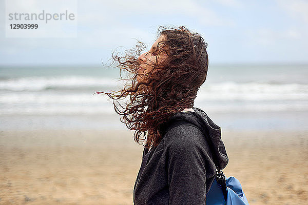 Weibliche Touristin mit fliegendem Haar am Strand  Las Palmas  Gran Canaria  Kanarische Inseln  Spanien