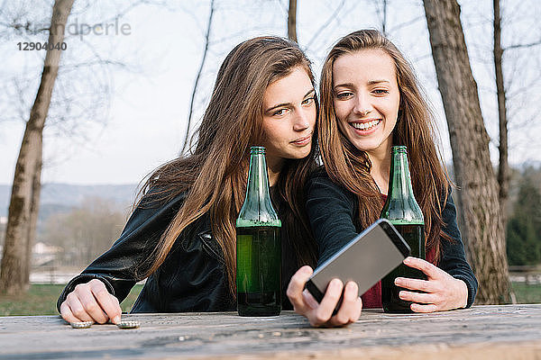 Freundinnen beim Selfie mit Bier im Park