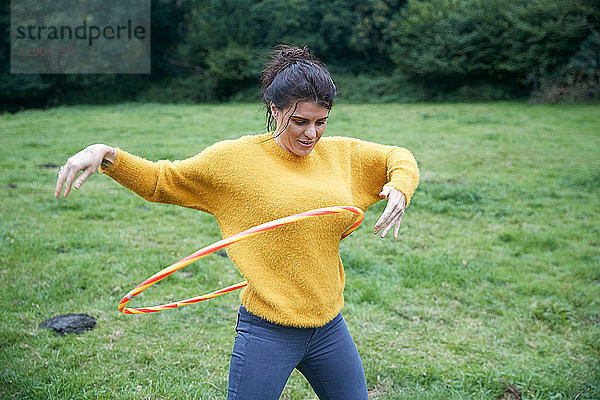 Frau beim Hula-Hoop-Reifen auf dem Feld