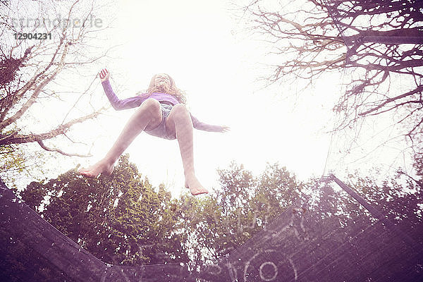 Mädchen springt auf Trampolin  niedriger Blickwinkel