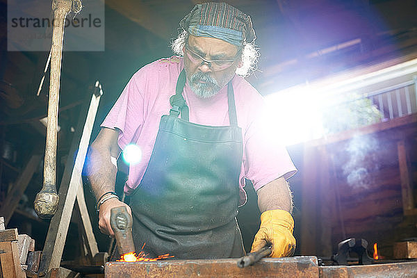 Der Schmied arbeitet in seiner Schmiede