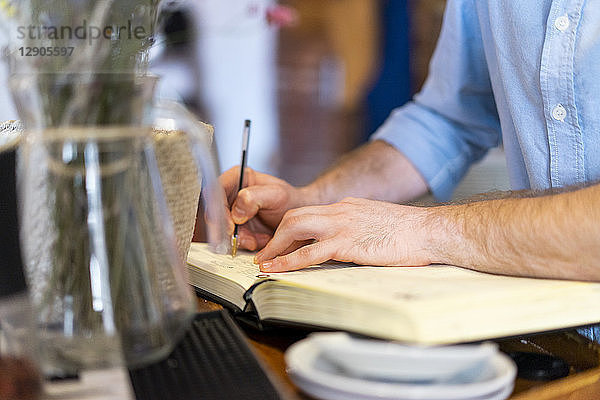 Close-up of man writing in notebook