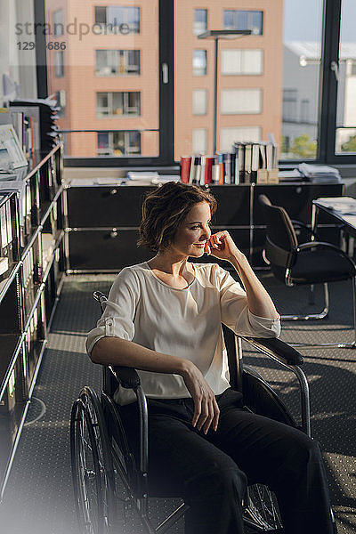 Disabled business woman sitting in wheelchair  smiling