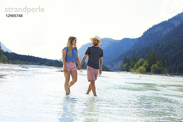 Young couple walking in water