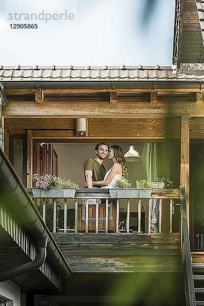 Happy affectionate couple on balcony at home