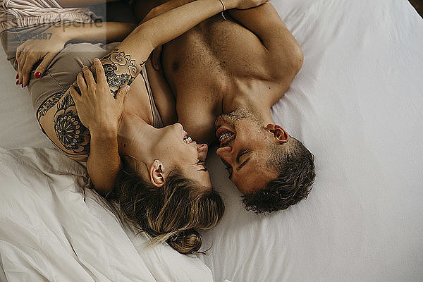 Romantic happy young couple lying in bed