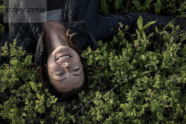 Top view of happy woman lying in a field