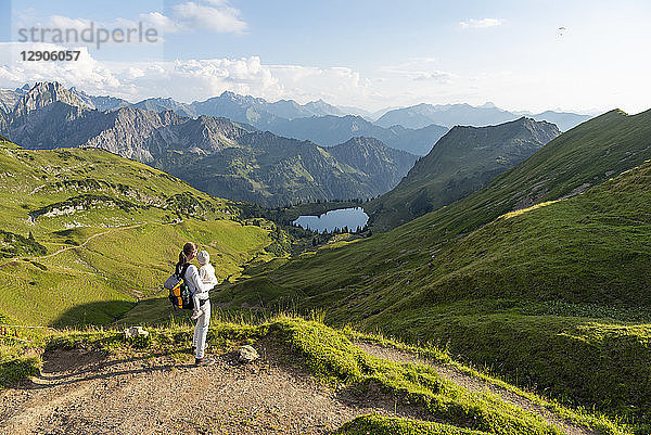 Germany  Bavaria  Oberstdorf  mother and little daughter on a hike in the mountains looking at view