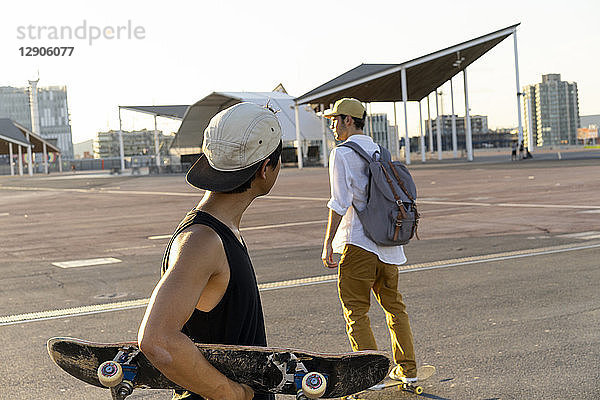 Two young men with skateboards on a parking level