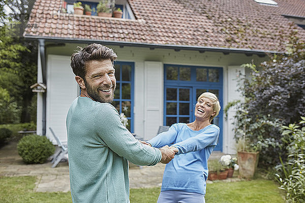 Happy couple dancing in front of their home