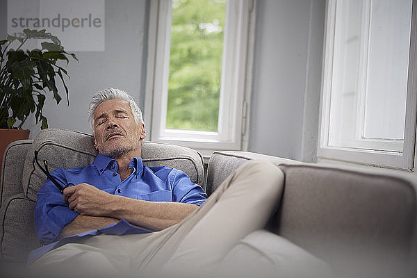 Portrait of mature man relaxing on couch at home