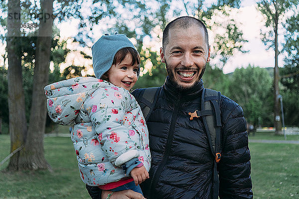 Portrait of father and little daughter having fun together in autumnal park