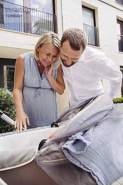 Happy couple looking into pram