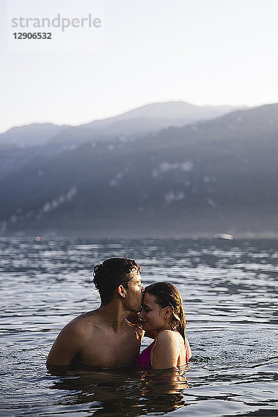 Affectionate young couple kissing in a lake