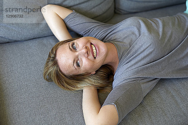 Laughing young woman relaxing on couch