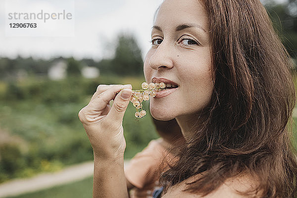 Portrait of woman eating white currants