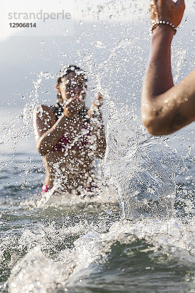 Happy young couple playing in a lake