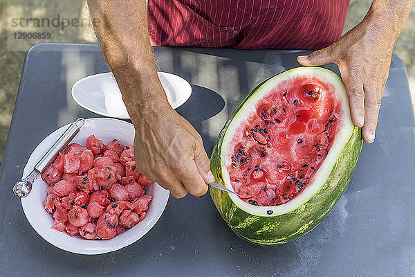 Close-up of man decorating a watermelon with carving tool