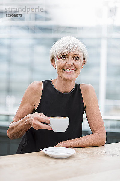 Portrait of smiling senior woman drinking a coffee