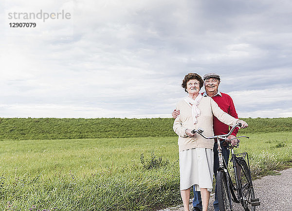 Senior couple with bicycles in rural landscape