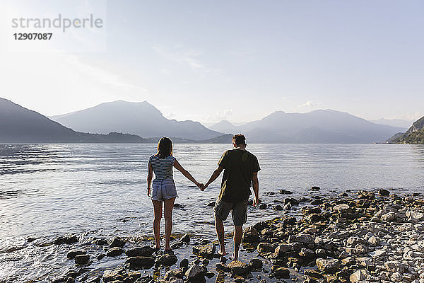 Young couple walking hand in hand at the lakeside
