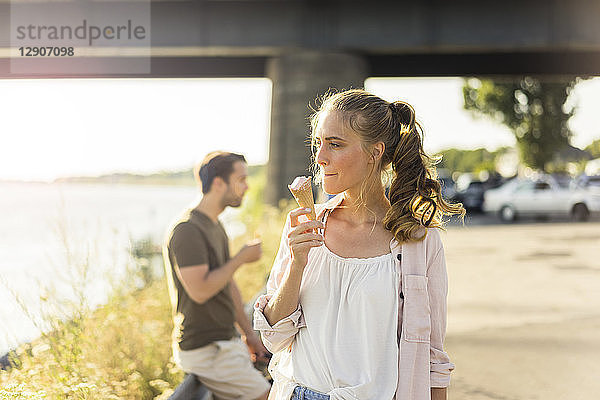 Couple eating ice cream in summer at the riverside