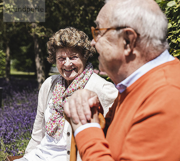 Senior couple sitting on bench in a park  talking