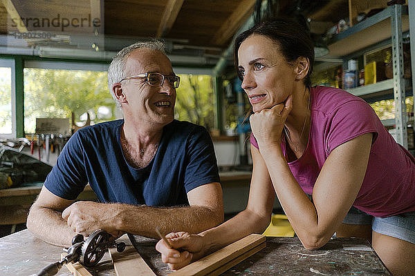 Smiling mature couple in workshop